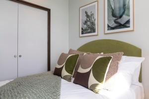 a bedroom with a bed with two pillows on it at Palm Tree House - Sahara in Orpington