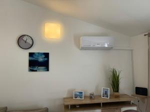 ein Wohnzimmer mit einer Uhr und Bildern an der Wand in der Unterkunft Apartment Sea Shell in Medulin
