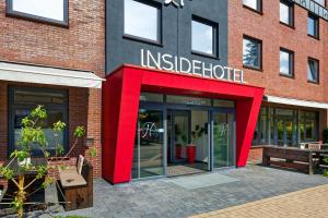 a building with a red entrance to an inside shelter at INSIDE Hotel Nordhorn in Nordhorn
