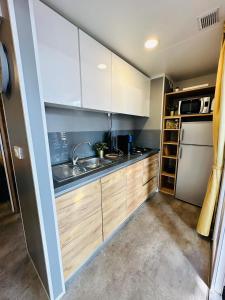 a kitchen with white cabinets and a sink and a dishwasher at Lucija Mobile Home in Biograd na Moru