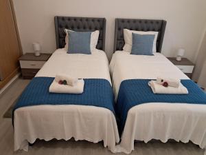Dos camas en una habitación con toallas. en My home en Cercal