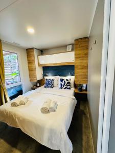 ein Schlafzimmer mit einem Bett mit zwei Hausschuhen darauf in der Unterkunft Lucija Mobile Home in Biograd na Moru