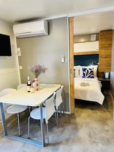 a room with a bed and a table and chairs at Lucija Mobile Home in Biograd na Moru