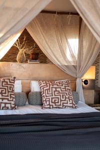 ein Bett in einem Zelt mit Kissen darauf in der Unterkunft Sandfontein Lodge & Nature Reserve in Sandfontein