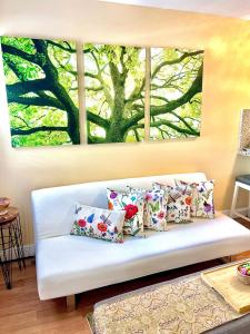 uma sala de estar com um sofá branco com uma pintura de árvore na parede em Private Guest House em Miami