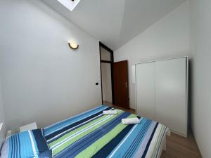 ein kleines Schlafzimmer mit einem Bett und einem Spiegel in der Unterkunft Apartment Sea Shell in Medulin