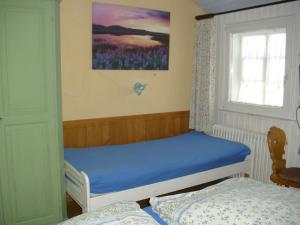 um pequeno quarto com uma cama e uma janela em Beautiful apartment in a Black Forest house with conservatory em Bernau im Schwarzwald