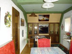 黑森林貝爾瑙的住宿－Beautiful apartment in a Black Forest house with conservatory，客厅配有桌子和红色椅子