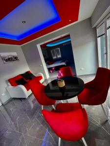 a living room with a table and red chairs at Apartment Deluxe Livno in Livno