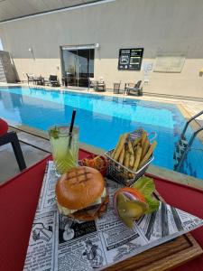 ein Tablett mit einem Sandwich, Pommes Frites und einem Drink in der Unterkunft Centro Al Manhal by Rotana in Abu Dhabi