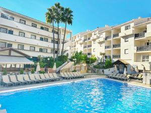 卡拉德米哈斯的住宿－馬貝拉皇冠度假俱樂部酒店，一座游泳池位于酒店前方,设有椅子和一座建筑
