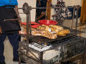 uma pessoa está cozinhando comida em uma grelha em Inkaba Resort & Conference Centre Kilifi em Kilifi