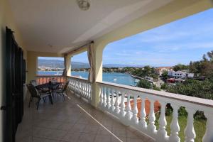 balkon ze stołem i krzesłami oraz widokiem na wodę w obiekcie Apartments in Silo - Insel Krk 13592 w mieście Šilo