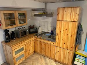 a kitchen with wooden cabinets and a sink at FeWo an der Küste in Elmenhorst