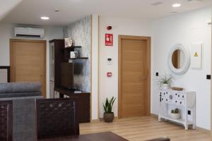 a living room with two wooden doors and a table at Apartamento Casa Cruceiro in Arzúa