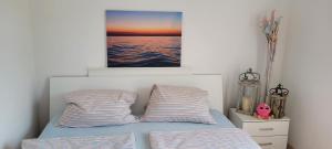 a bed with two pillows and a picture on the wall at PomaloVilla at Gradina Cove in Vela Luka