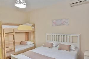 a bedroom with two bunk beds and a lamp at GREEK PRIDE PANTHEA STUDIOS in Skala Fourkas