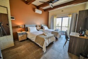 a hotel room with two beds and a balcony at 49 Sunrise Lodge in Għajnsielem