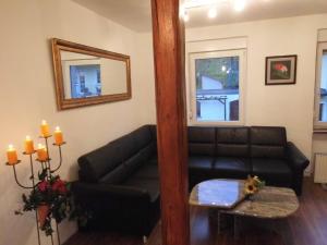 sala de estar con sofá negro y mesa en Comfortable Holiday Home near Vineyards in Bremm, en Bremm