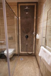 y baño con ducha y aseo. en Hotel Maharaja Palazzo en Ludhiana
