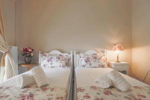 two beds sitting next to each other in a bedroom at Mon Repos Deluxe Apartment by Corfuescapes in Anemómylos