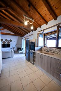 a large kitchen with wooden ceilings and a large island at Villa Lazareta in Punta