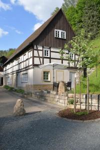 een groot wit en bruin huis met een boom ervoor bij Gründelstube in Bad Schandau