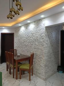 a dining room with a table and chairs and a brick wall at شالية غرفتين و صالة ببورتوسعيد Family ONLY in Port Said