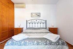 een slaapkamer met een bed met 2 dressoirs en 2 handdoeken bij CT 271 AL - Faro's La Paz - Pozo de los Frailes in El Pozo de los Frailes