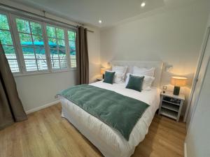 - une chambre dotée d'un grand lit avec des draps et des oreillers verts dans l'établissement Villa Elisabeth, à Versailles