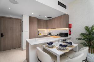 a kitchen with a white table and white chairs at Nasma Luxury Stays - Laya Heights in Dubai