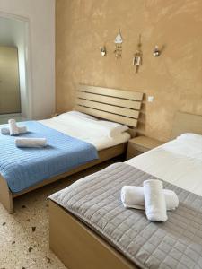a bedroom with two beds with towels on them at Santa Marina Rooms in Agia Marina Aegina