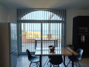 カルカトッジョにあるLes Sables Blancs de la Lisciaのダイニングルーム(テーブル、椅子付)、大きな窓が備わります。