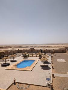 a resort with a swimming pool in the desert at Traditional Riad Merzouga Dunes in Merzouga