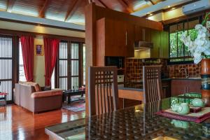 a kitchen and living room with a glass table and chairs at Large 4 bed villa short walk to Maenam beach in Mae Nam