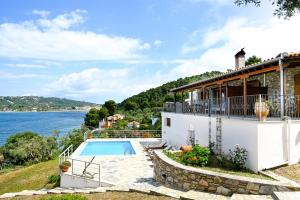 a house with a swimming pool next to the water at Villa Lazareta in Punta