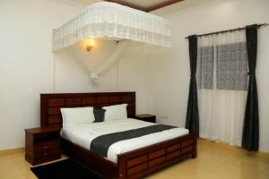 um quarto com uma cama de dossel grande em Fort Breeze Hotel em Fort Portal