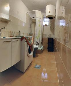 Un baño con lavadora y un inodoro. en Selena, en Vir