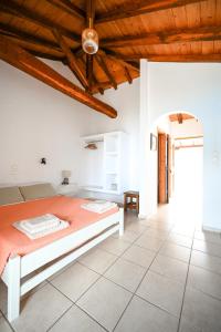 Villa Lazareta في Punta: غرفة نوم بيضاء بسرير وسقف خشبي