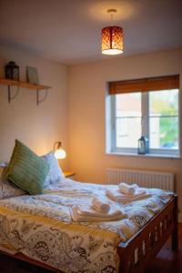 a bedroom with a bed with towels on it at Marley's Coach House - Frome in Frome