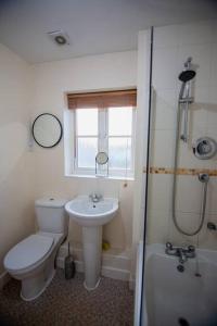 a bathroom with a toilet and a sink and a shower at Marley's Coach House - Frome in Frome