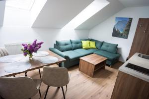 a living room with a blue couch and a table at Apartmány Banff in Bešeňová