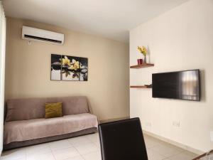 a living room with a couch and a flat screen tv at Sea views apartment-wifi-sleep 5 in Marsaskala