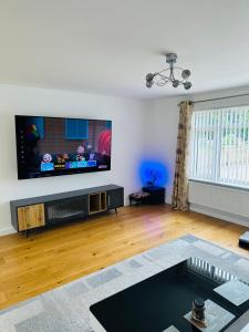 sala de estar con TV de pantalla plana en la pared en "Tranquil Village Hideaway Bungalow"near Kings Lynn en Kings Lynn
