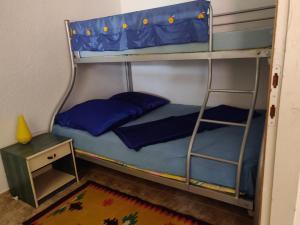 Una litera con almohadas azules y una mesa auxiliar. en Selena, en Vir