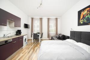 ウィーンにあるApartment Huglgasseのベッドルーム1室(ベッド1台付)、キッチン、リビングルームが備わります。