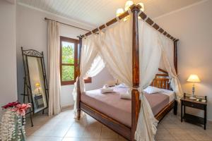 a bedroom with a canopy bed and a mirror at Santa Elena Boutique Rooms in Chania