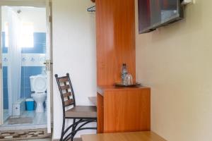een kamer met een tafel, een stoel en een toilet bij Mayas Suites in Nyeri