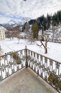 a balcony with a snow covered yard with a fence at Scuol Palace Bed & Breakfast in Scuol
