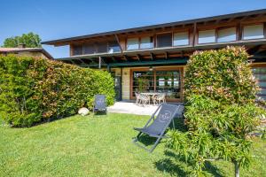 a house with a yard with a table and chairs at TOCAI Golf & Family Retreat Lignano in Lignano Sabbiadoro
